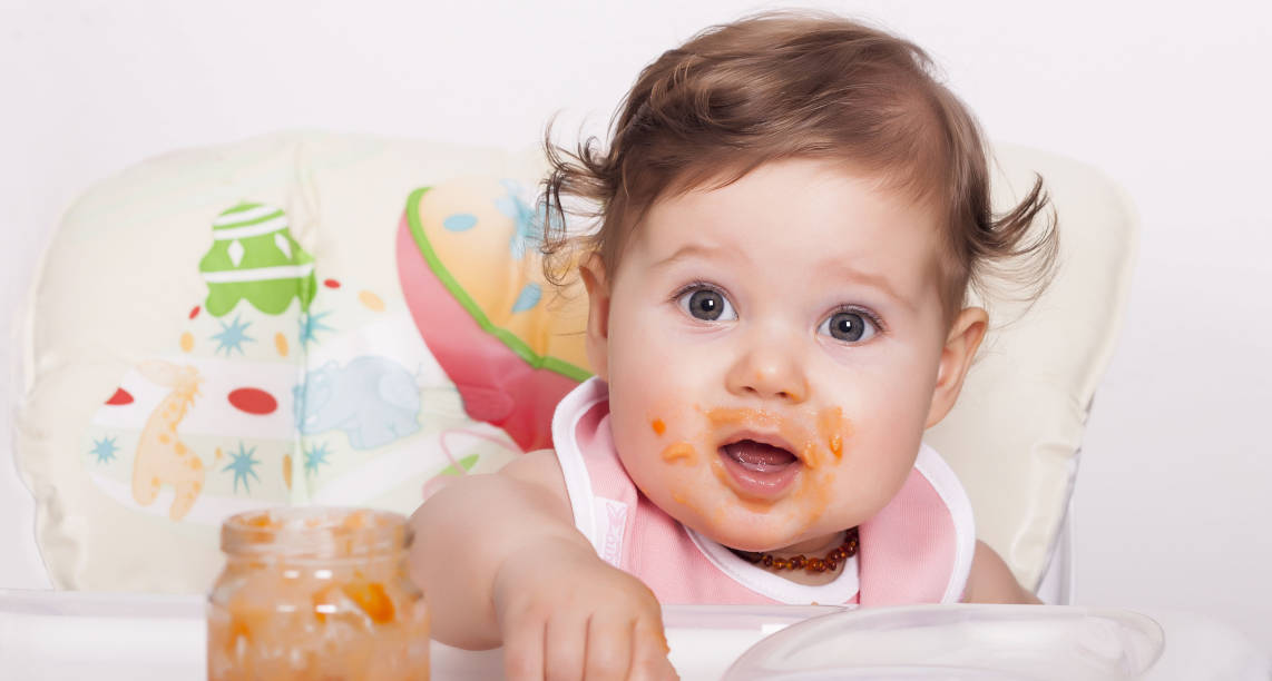 Adorable smudgy female baby eating her favorite food